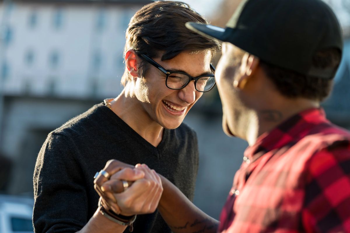 A sober living home director and a resident talking and laughing together outside